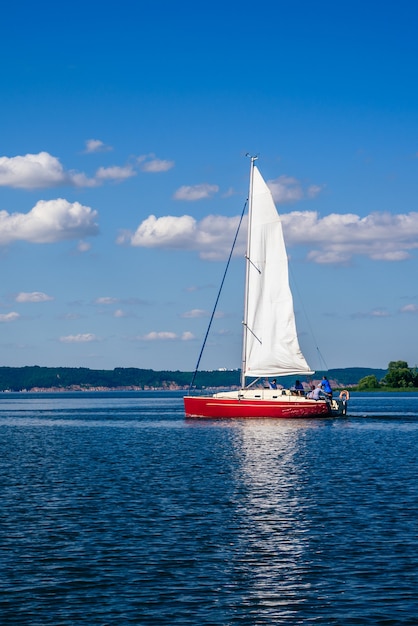 Bateau à voile rouge sur la rivière à Sunny Day.