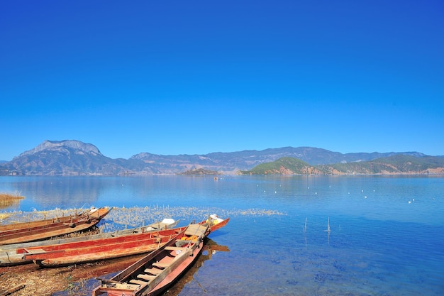 Photo des bateaux amarrés au bord du lac contre un ciel bleu clair