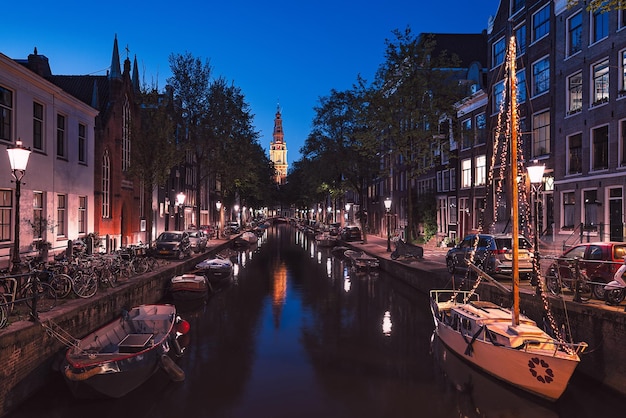 Des bateaux amarrés dans un canal au milieu des bâtiments la nuit.