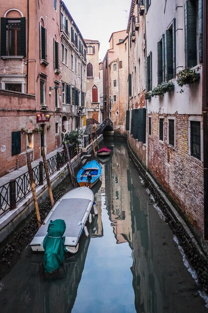 Photo des bateaux amarrés dans un canal au milieu des bâtiments