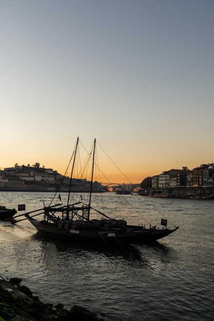 Bateaux appelés Rabelos sur le fleuve Douro à Porto et en arrière-plan le coucher du soleil