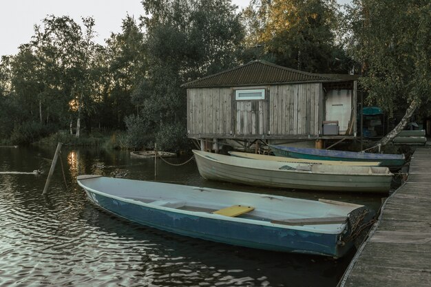 Bateaux en bois au quai avec maison de pêcheur le soir.