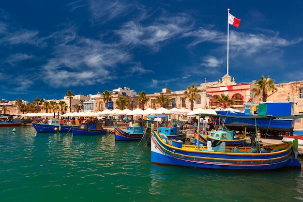 Bateaux colorés aux yeux traditionnels Luzzu dans le port du village de pêcheurs méditerranéen Marsaxlokk, Malte