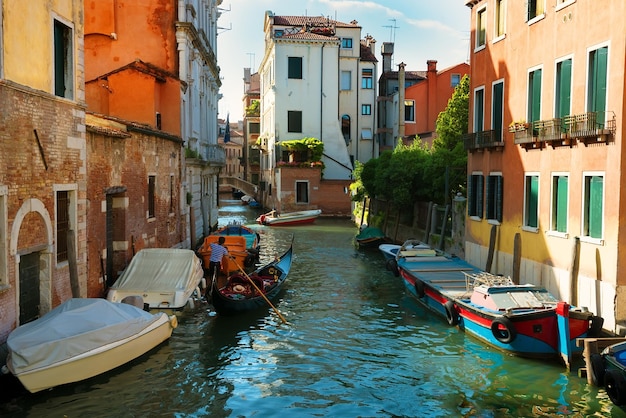 Bateaux dans l'étroit canal d'eau vénitien, Italie