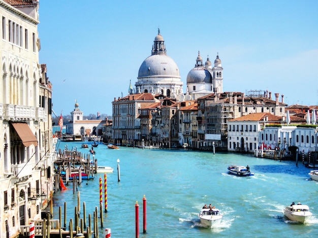 Des bateaux dans le Grand Canal avec le salut de Santa Maria della contre le ciel