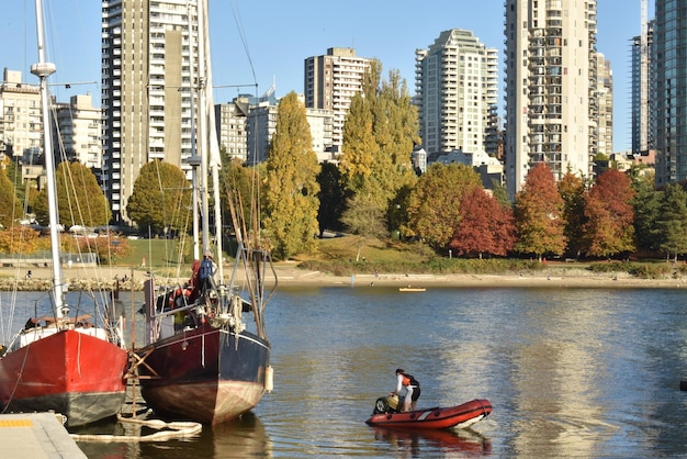 Photo des bateaux dans la rivière par ville contre un ciel clair