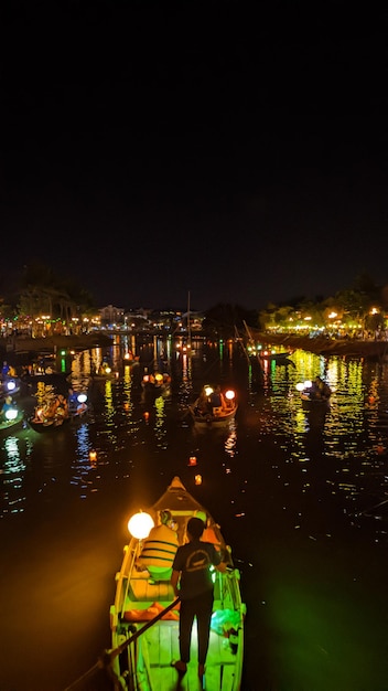 Photo bateaux sur l'eau la nuit avec des lumières allumées