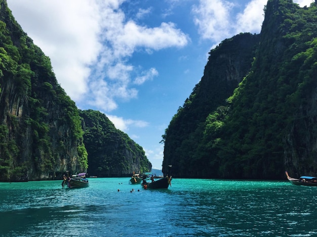 Des bateaux en mer par les montagnes contre le ciel