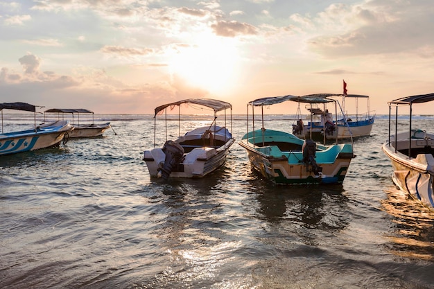 Bateaux de pêche au coucher du soleil sur la plage