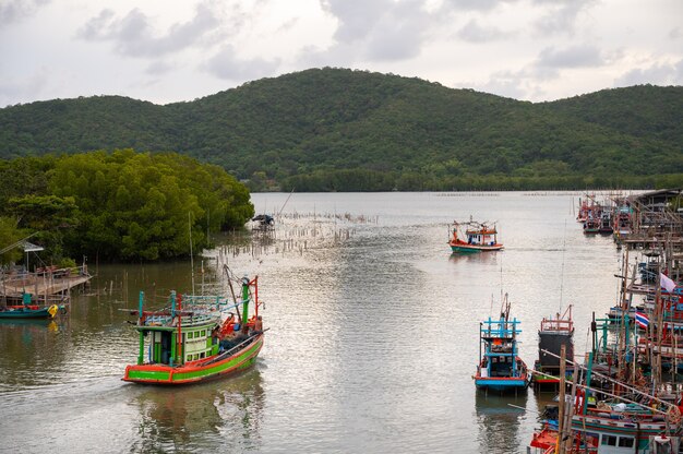 Les bateaux de pêche thaïlandais naviguent en mer le soir au coucher du soleil.