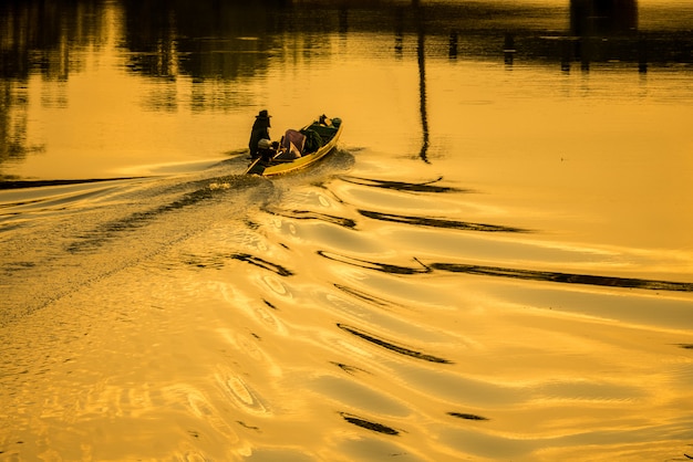 Bateaux et pêcheurs sur la rivière au calme.