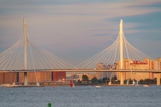 Bateaux à voile à l'arrière-plan du nouveau pont à haubans au coucher du soleil