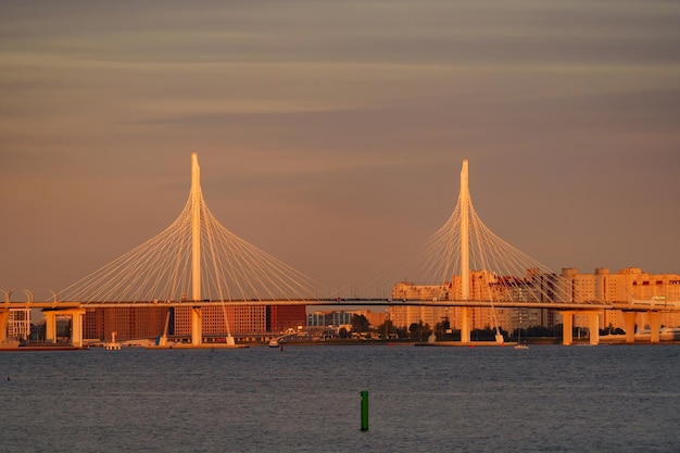 Bateaux à voile à l'arrière-plan du nouveau pont à haubans au coucher du soleil