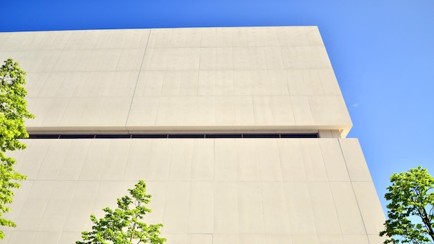 un bâtiment avec un arbre devant lui qui a un ciel bleu derrière lui