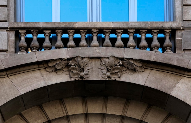 Un bâtiment avec un balcon et un visage au sommet.