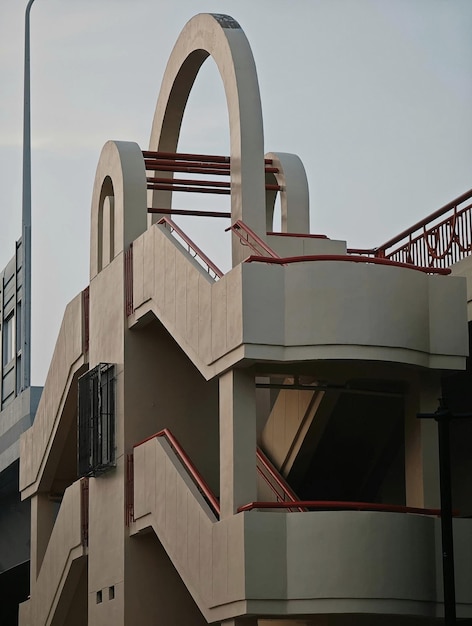 Un bâtiment avec une balustrade rouge et un escalier au sommet.