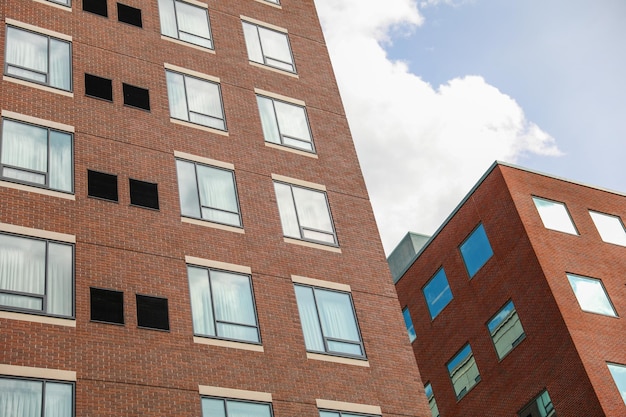 Un bâtiment en brique avec des fenêtres sur le côté et un ciel bleu en arrière-plan.