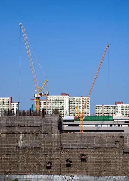 Bâtiment de chantier avec grue jaune et échafaudage