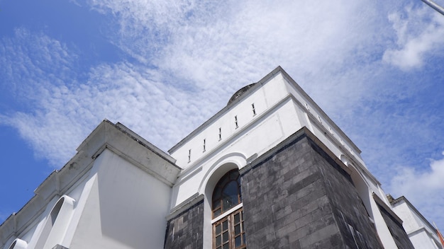 Un bâtiment avec un ciel bleu et des nuages