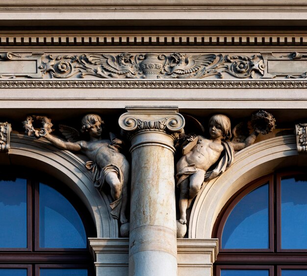 Un bâtiment avec une colonne avec deux anges dessus