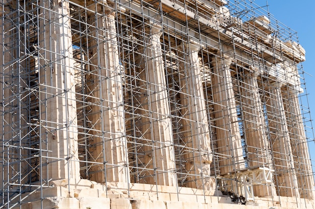 Un bâtiment entouré d'échafaudages et derrière un ciel bleu.