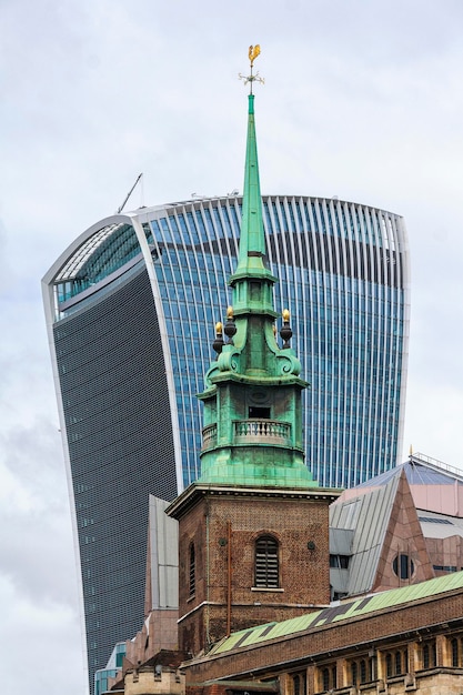 Photo un bâtiment avec un grand clocher vert et un bâtiment en verre derrière