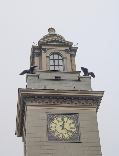 Bâtiment gris avec une horloge contre un ciel gris