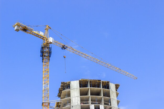 Bâtiment grue et bâtiment en construction contre le ciel bleu