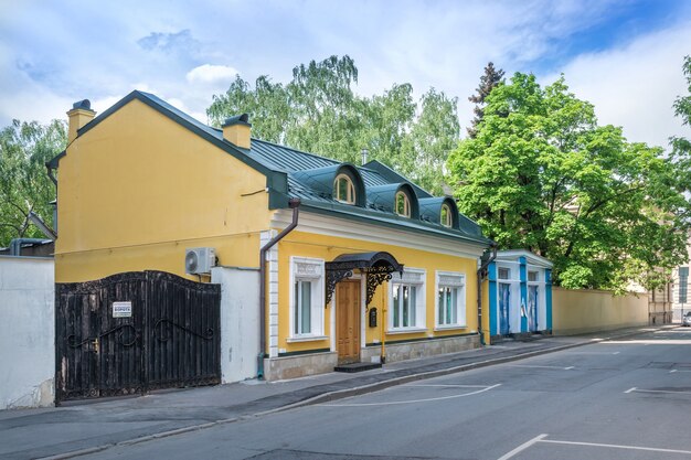 Un bâtiment jaune à Khlebny Lane à Moscou par une journée ensoleillée d'été. Légende : Attention ! Portails automatiques