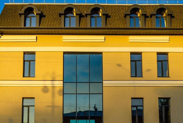 Un bâtiment jaune avec un toit bleu et un toit noir.