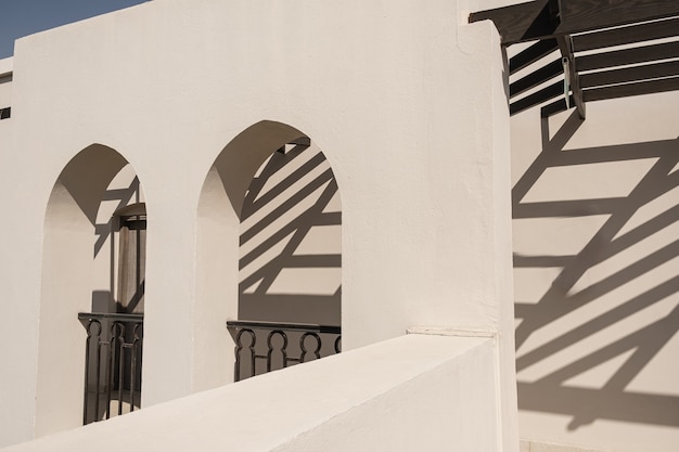 Bâtiment moderne de style oriental avec murs beiges, fenêtres et ombres du soleil sur les murs