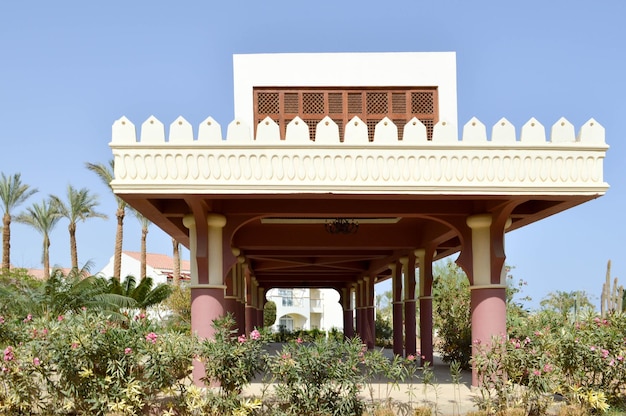 Un bâtiment en pierre blanche avec des colonnes de style latin mexicain sur fond de tropical exotique