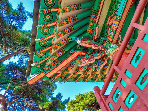 Un bâtiment avec une porte rouge et un toit vert