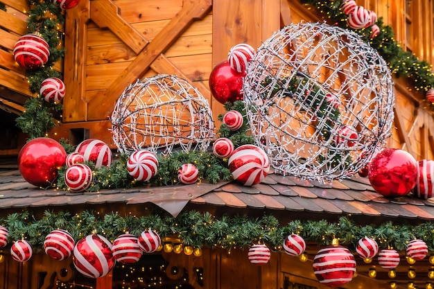 Bâtiment de restaurant rétro en bois décoré de sapin artificiel avec guirlande et de nombreuses boules de Noël rouges et blanches