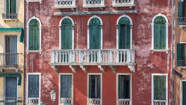 Un bâtiment rouge avec un balcon et un lampadaire vert