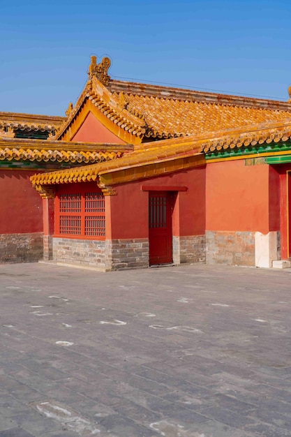 Un bâtiment rouge avec une porte rouge et un toit jaune.