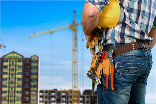 Un bâtiment urbain en construction avec des grues travaillant pour déplacer des matériaux de construction sur le site