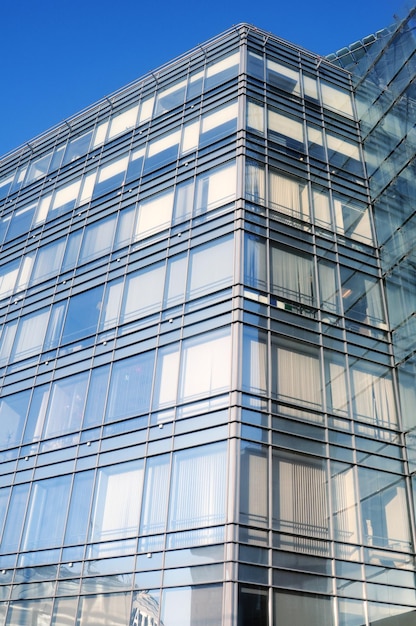 Photo un bâtiment en verre avec un ciel bleu derrière lui