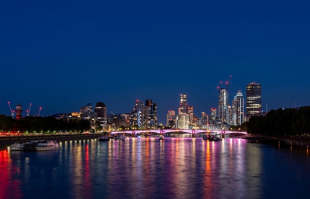 Des bâtiments éclairés par la rivière contre le ciel la nuit