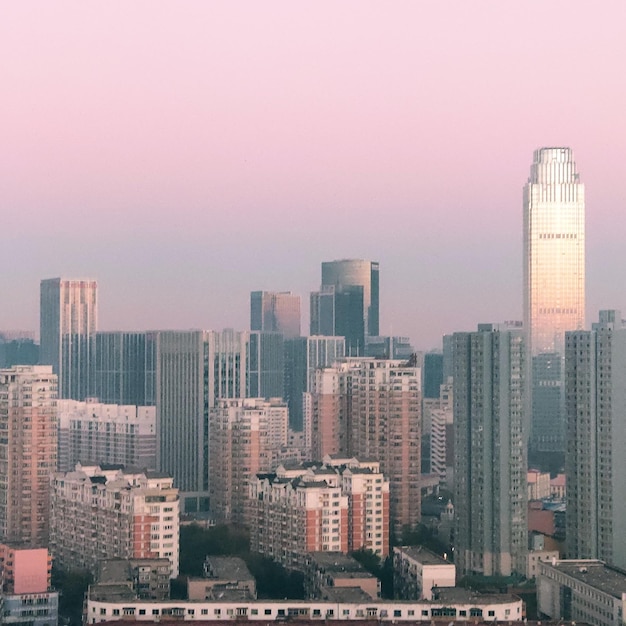 Bâtiments modernes dans la ville contre le ciel au coucher du soleil