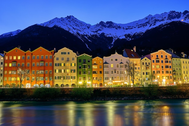 Photo des bâtiments par des montagnes contre le ciel la nuit