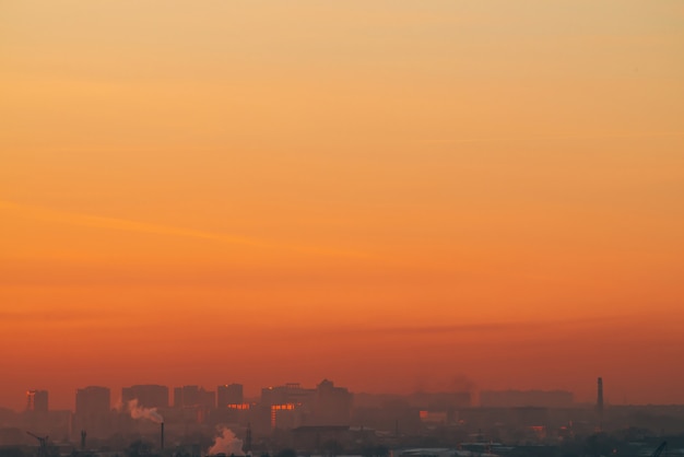 Bâtiments urbains derrière des maisons privées au coucher du soleil