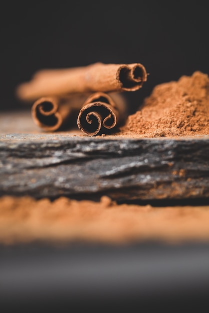 Bâton de cannelle et poudre sur fond noir avec pierres