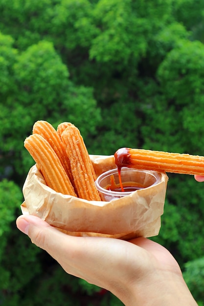 Bâton de Churro alléchant après trempé dans une sauce au caramel