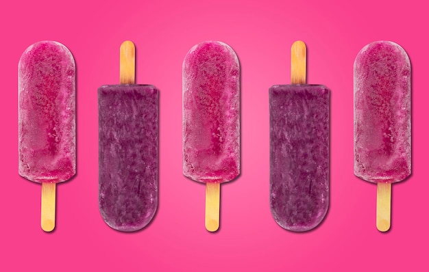 Bâton de glace aux fruits popsicle sur fond violet et rose popsicle fraise rose