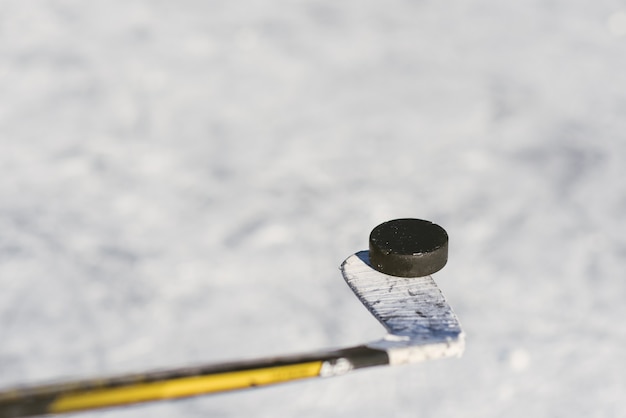 Bâton et rondelle en gros plan sur le fond de glace