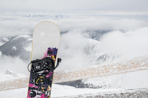 Bâton de snowboard dans les montagnes enneigées sur fond