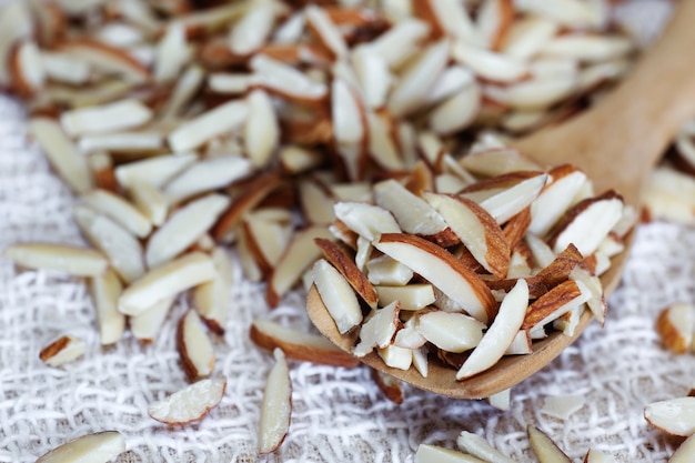 Bâtonnets d&#39;amandes sur une cuillère en bois avec gros plan