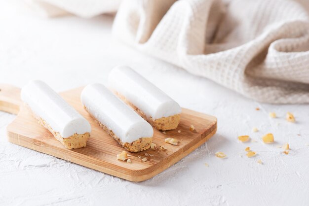 Bâtonnets de carottes crues avec crème de noix de coco sur une planche de bois. Sans sucre, gluten et lactose et végétalien.