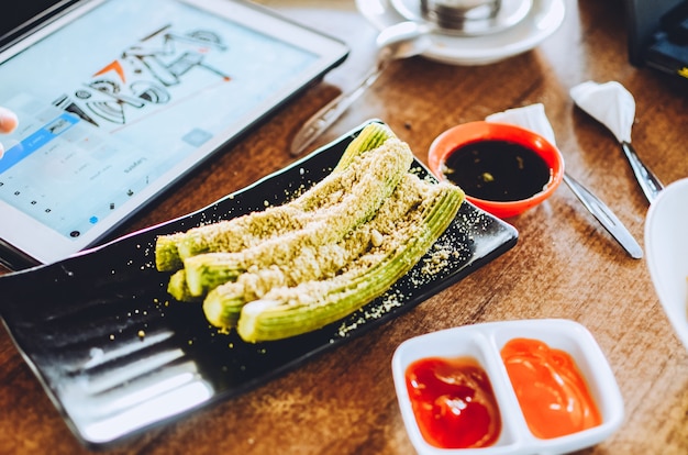 Bâtonnets de churros avec du sucre et de la sauce au chocolat sur la table.